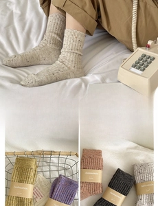 Close-up of thick wool socks with rib knit texture and colorful speckled pattern