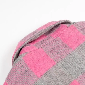 Detailed close-up of pink and grey plaid flannel shirt collar with soft fabric texture