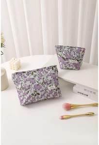 Detail of purple floral embroidered canvas makeup bags with heart-shaped zipper pulls