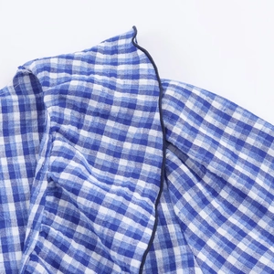 Detailaufnahme von blau-weißem Karo-Hemdstoff mit dunkelblauer Paspelierung