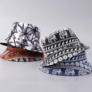 Close-up of canvas bucket hats featuring palm leaf, geometric and elephant prints