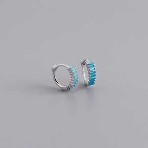 Detailed close-up of S925 silver huggie earrings with channel-set turquoise blue stones
