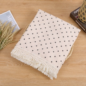 Close-up of double-layer cotton baby blanket with black stars and fringe details
