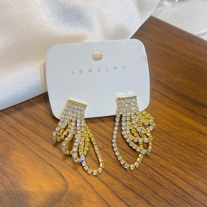 Close-up of elegant gold tassel earrings with zircon fringe on jewelry display card