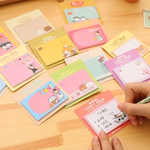 Macro detail of cute animal cartoon sticky notes with hand writing a memo on wood desk