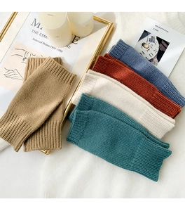 Detailed knit texture of cozy fingerless arm warmers in various autumn colors