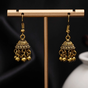 Macro shot of vintage golden bell earrings featuring intricate floral carving and tiny metal beads