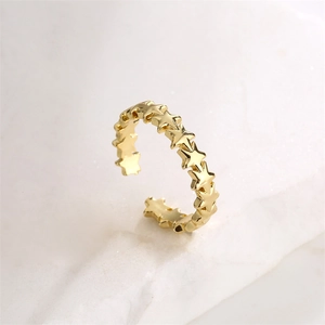 Détail de la bague étoile dorée ajustable sur marbre avec une brillance métallique vive