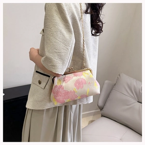 Elegante bestickte Muscheltasche mit Goldkette, getragen von einem Modenmodell