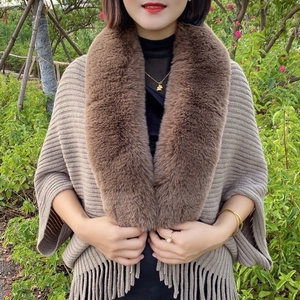 Detailed view of the brown knit shawl featuring a plush faux fur collar and fringed hem