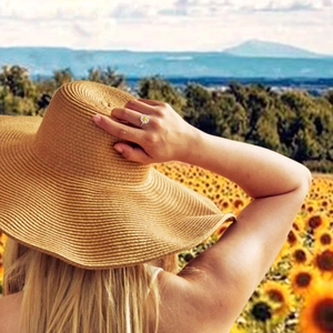 Daisy ring worn by woman in sunflower field showcasing the floral silver and gold design