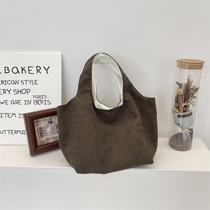 Close-up of brown corduroy tote bag with textured stripes and soft cotton lining