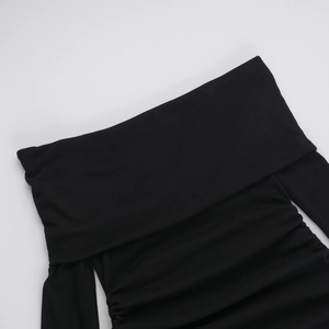 Dettaglio del tessuto in maglia a costine nera e dello scollo a barca sul vestito