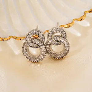 Sparkling silver figure-eight stud earrings with micro-pave zircons on a silk background