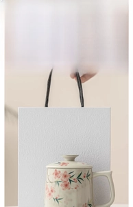 Detail of peach blossom ceramic tea mug with ash glaze and matching gift bag