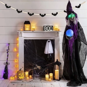 Standing Halloween witch figure with glowing eyes and blue sphere by the fireplace