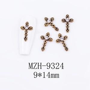 Macro shot of 9x14mm vintage gold cross nail charms with rhinestone on white background