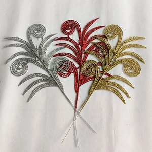 Detailed view of hollowed Christmas leaves with glitter coating in gold, silver, and red