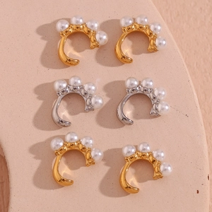 Détail macro du lot de 6 bagues d'oreilles perles dorées et argentées sur plateau