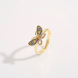 Adjustable gold butterfly ring with colorful cubic zirconia inlays on a grey background