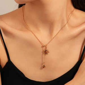 Close-up of vintage sun flower necklace with faux tiger eye stone on adjustable gold chain