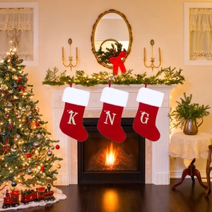 Personalized Christmas stockings with gold initials K, N, G on festive fireplace mantel