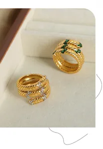 Detailansicht strukturierter Schlangenringe in Gold mit grünen und weißen Zirkonia-Steinen