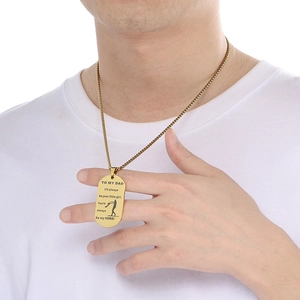 Close-up of golden dog tag necklace for dad with sentimental message on a model