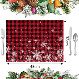 Detalle del mantel individual navideño a cuadros rojos y negros con copos de nieve