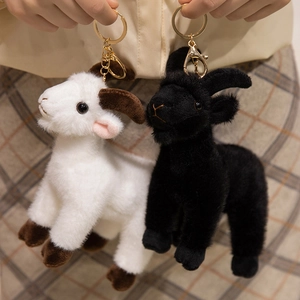 Plush goat keychains in black and white with soft fur and golden metal lobster clasps