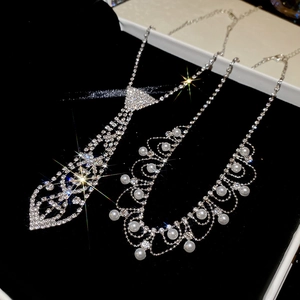 Detailed view of silver tie-shaped rhinestone necklace and elegant pearl fringe jewelry