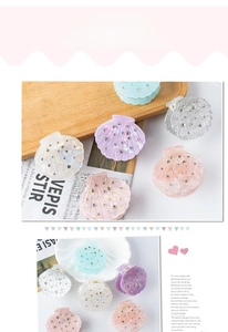 Gros plan sur des pinces à cheveux en acrylique en forme de coquillage et strass