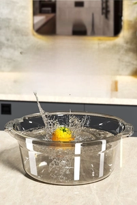 Macro shot of deep transparent plastic washbasin with water splash in kitchen