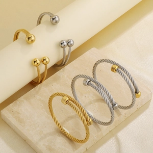 Detailed view of twisted cable titanium steel open bangles in gold and silver finishes