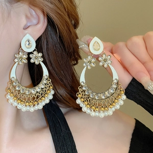 Close-up of bohemian hollow-out moon earrings with pearls and crystals on a model