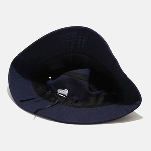 Detailed internal view of navy blue bucket hat showing 100 percent cotton fabric and label