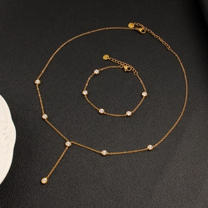 Golden stainless steel jewelry set with sparkling crystals featuring Y-necklace and bracelet
