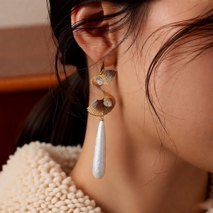 Detail of twisted gold drop earrings with sparkling rhinestones and elegant pearls