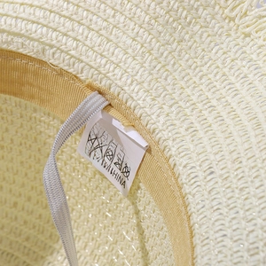 Dettaglio cappello in paglia con fascia tergisudore interna e cinturino elastico bianco