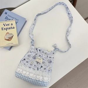 Detail view of blue floral and plaid patchwork crossbody bag with lace accents