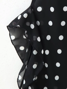 Detailed view of polka dot print pattern and ruffled sleeve hem on a summer dress