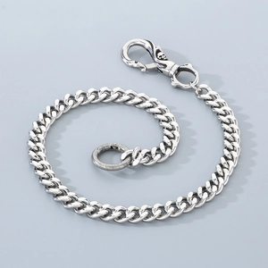 Detail of silver stainless steel Cuban link pants chain with a skull head spring clasp