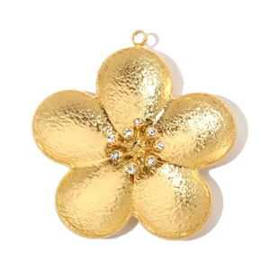 Close-up of golden flower pendant with shimmering rhinestones and textured metal petals