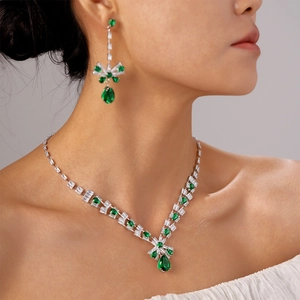 Luxury bow necklace and earrings set with green teardrop gems and white zircons