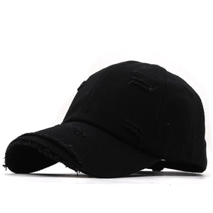 Detailed view of the distressed ripped edges on a black cotton vintage baseball cap