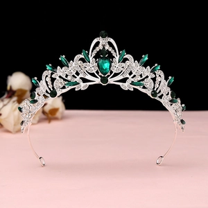 Macro detail of Baroque silver crown with emerald green gemstones and clear crystals