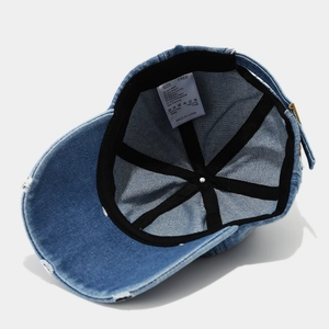 Détail de l'intérieur d'une casquette en jean montrant les coutures renforcées et l'étiquette