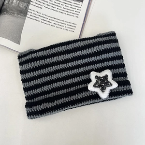 Detailed view of black and gray striped knit beanie with silver star sequin embroidery