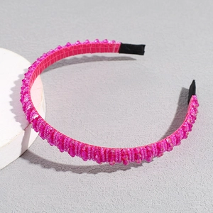 Detail of a thin fuchsia crystal headband with handcrafted transparent beads and black fabric tips
