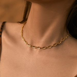 French style 18K gold-plated oval link chain necklace worn by a model in warm lighting